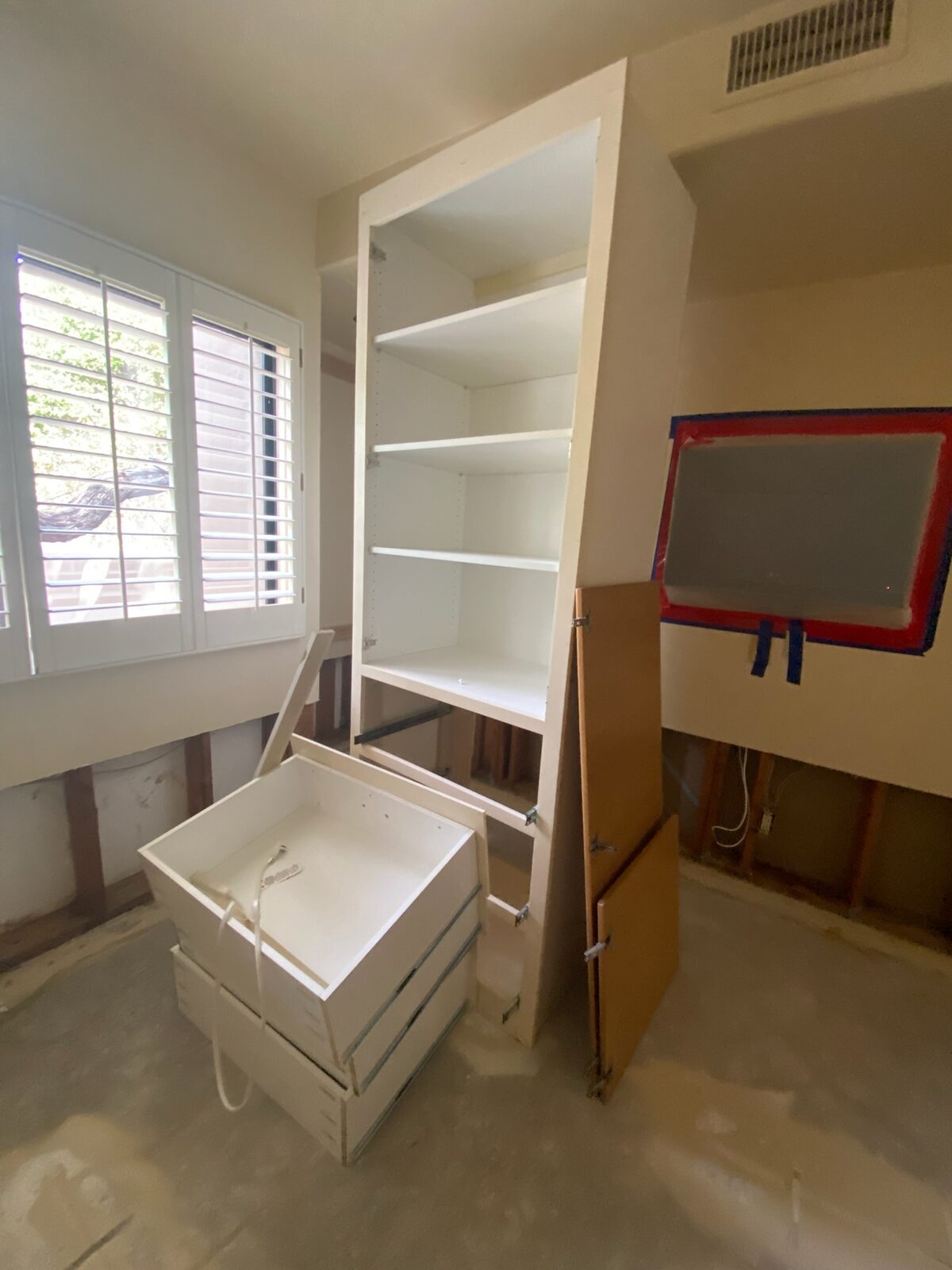 Built in shelving unit being removed in a room prepared for drying
