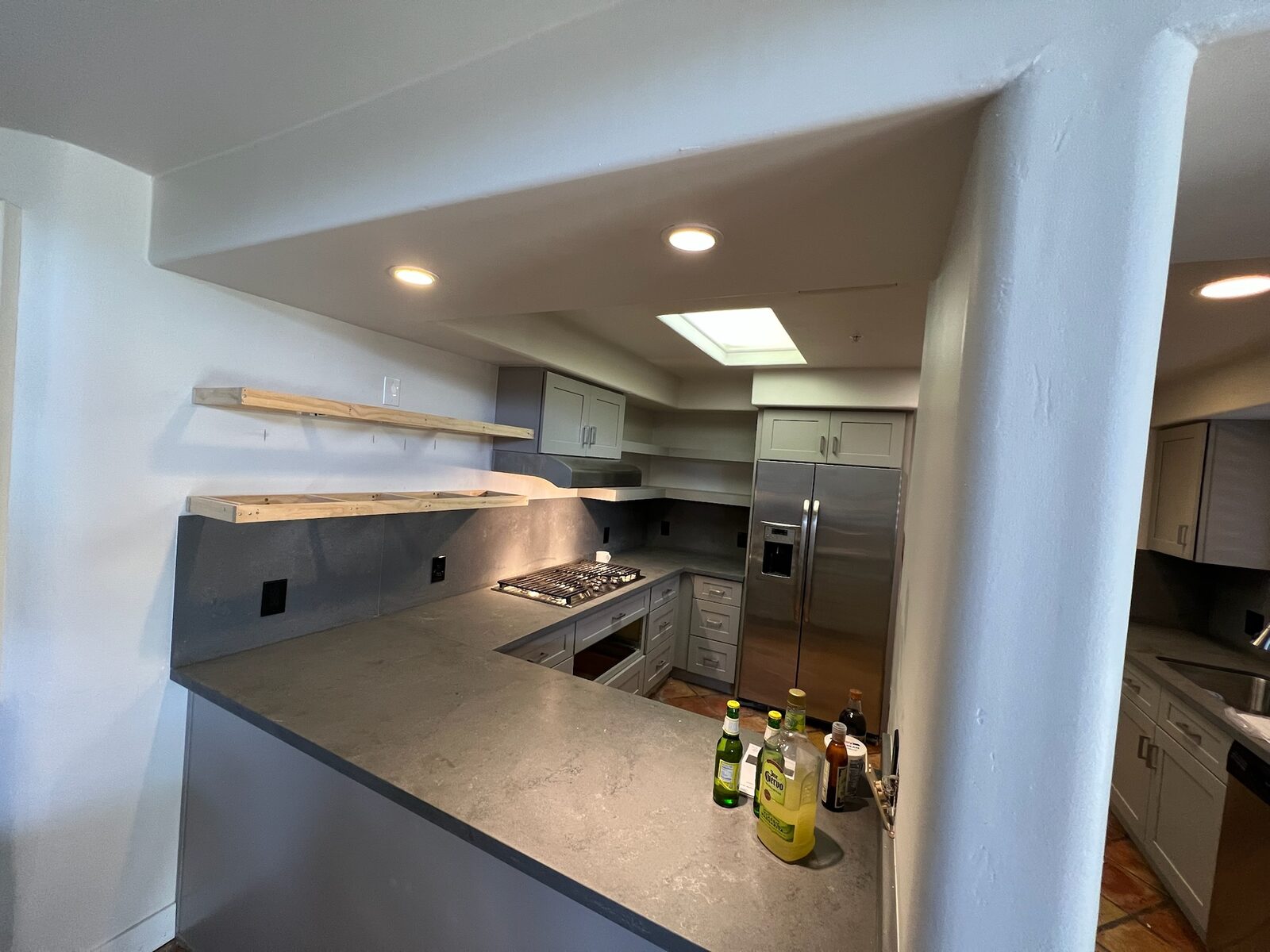 Floating shelf supports mounted above a stone backsplash during a kitchen remodel