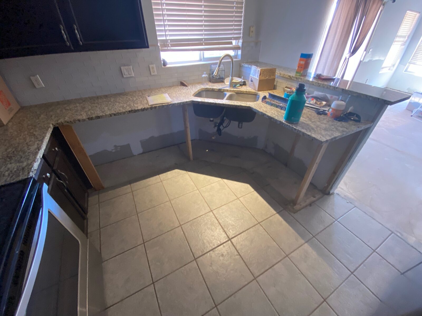 Granite counter and sink supported on temporary framing after base cabinet removal
