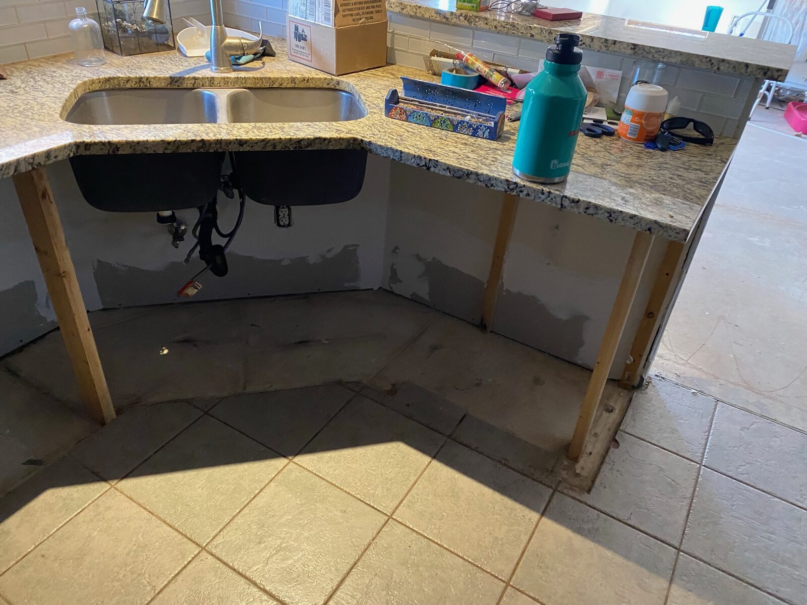 Granite countertop and sink held on temporary bracing after base cabinet removal