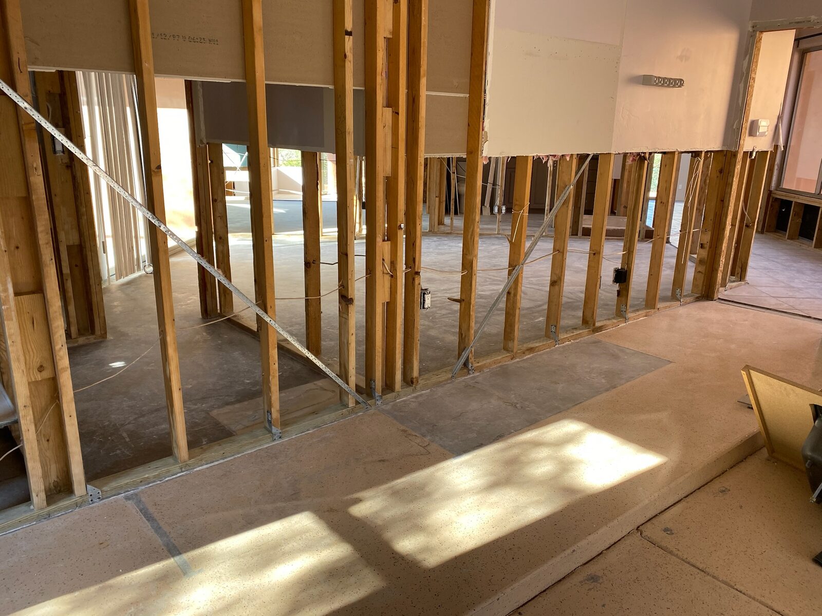 Interior walls stripped to wood studs with concrete floor exposed during demolition