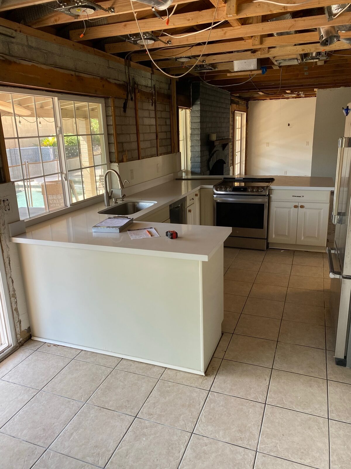 Kitchen with ceiling drywall removed exposing wood joists during a remodel