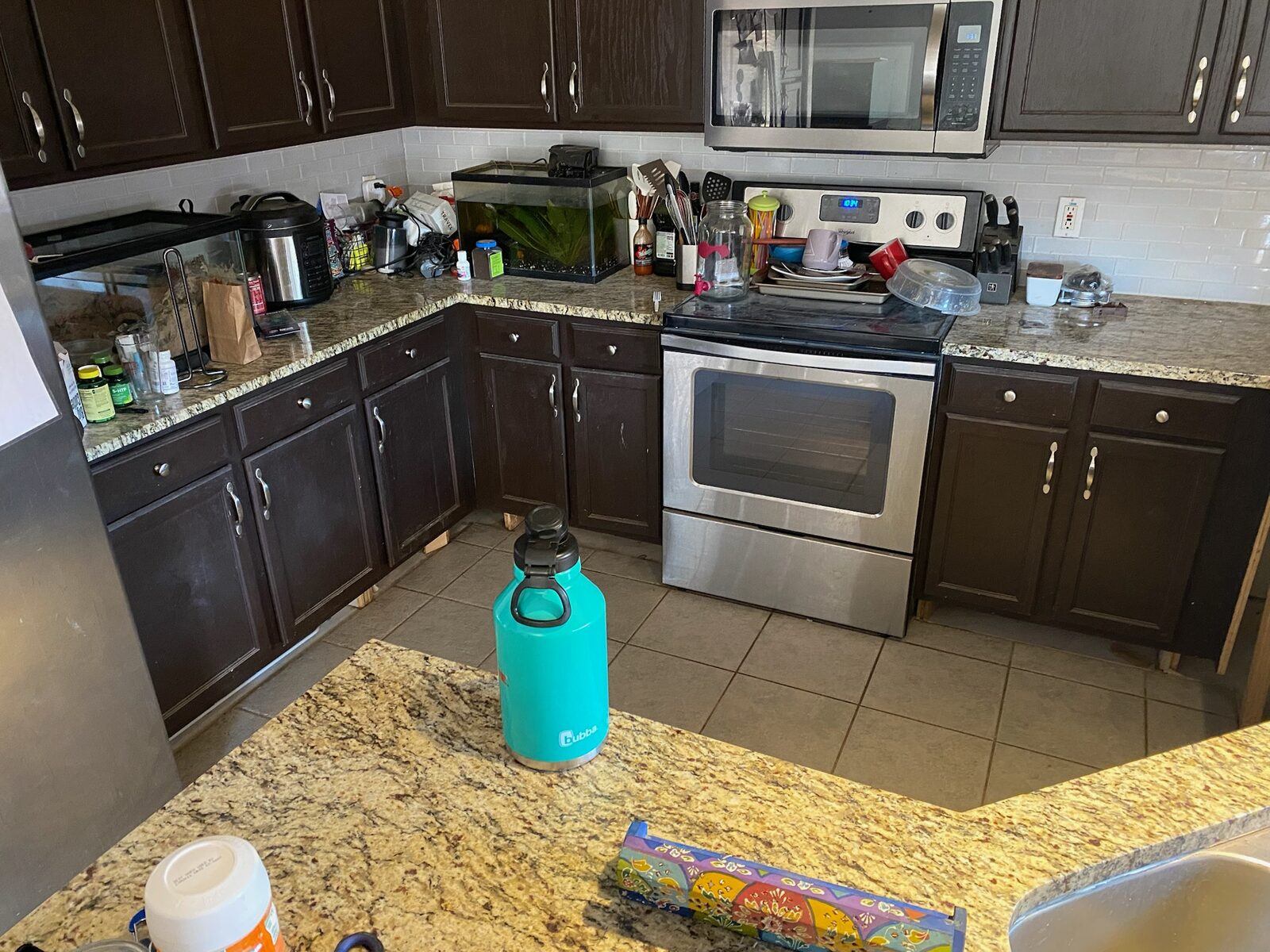 Kitchen with dark cabinets, granite countertops, tile backsplash and stainless range