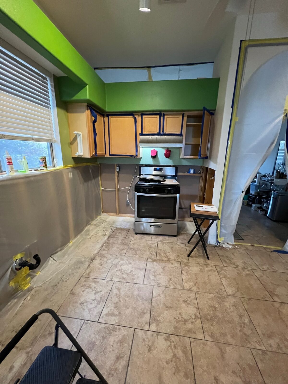 Kitchen prepared with plastic sheeting and masking tape before restoration work