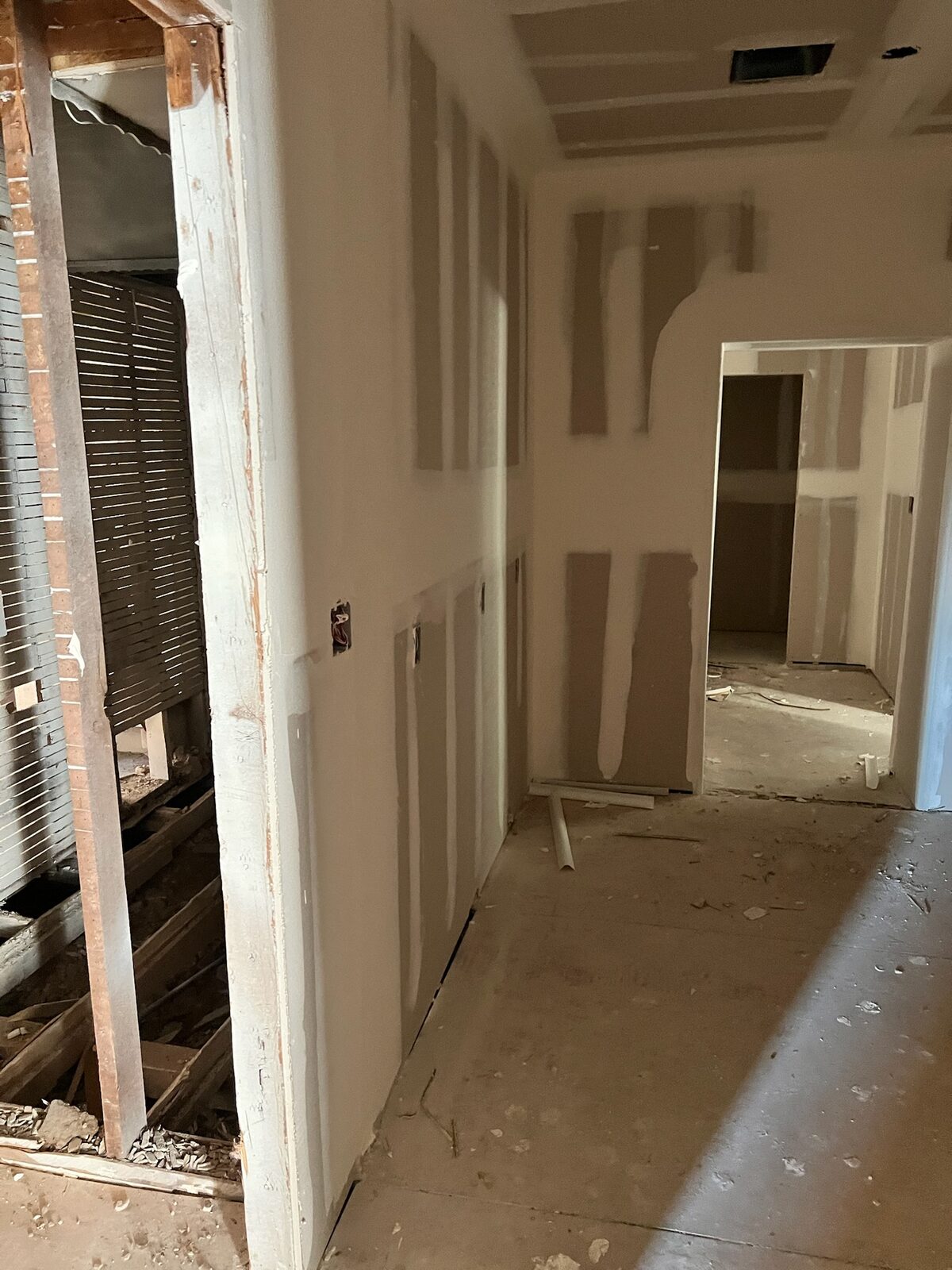 New drywall hung and taped along a hallway during reconstruction