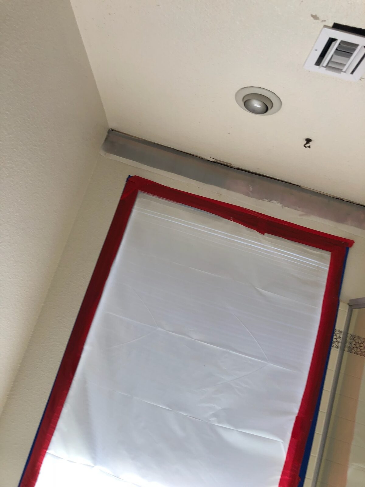 Plastic containment barrier taped over a doorway during interior demolition
