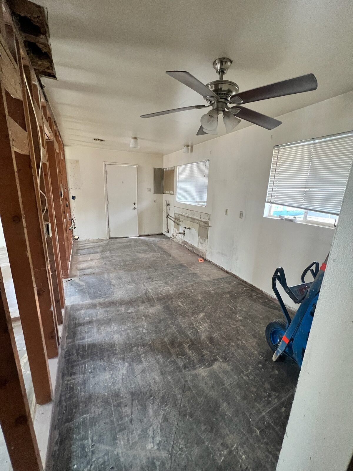 Room gutted to subfloor with one wall opened to the studs