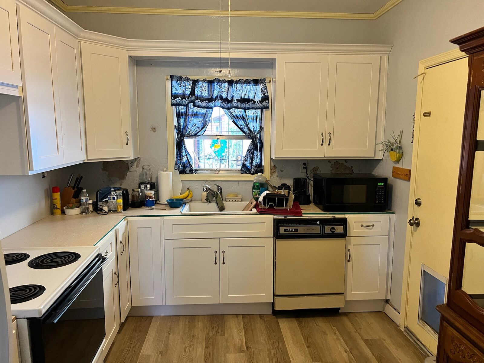 White shaker cabinets installed in a kitchen with wood look flooring
