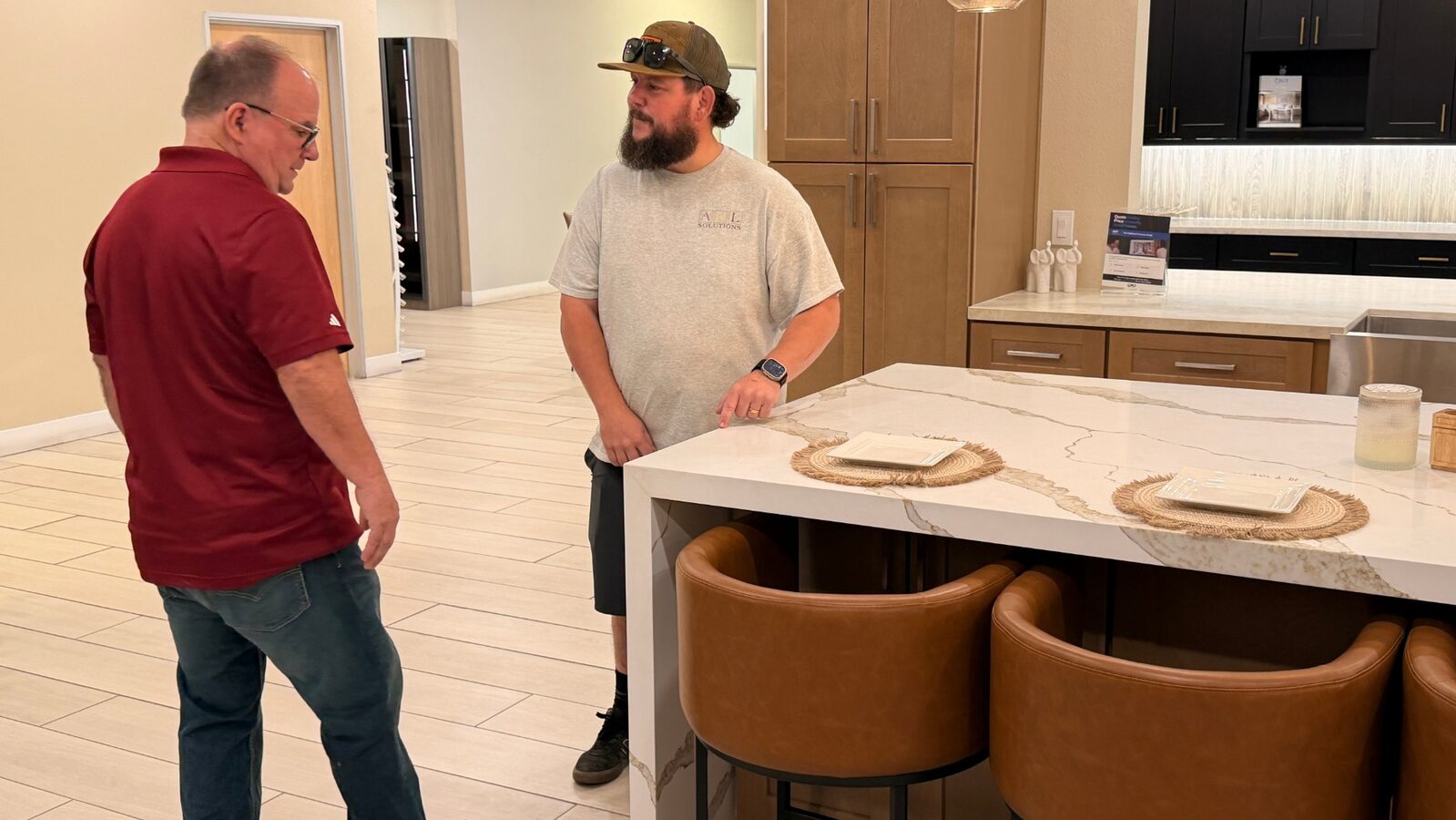 Jim Bennett and Brandon Gurr standing at a kitchen island in a cabinet and countertop showroom.